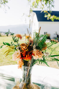 Wedding flowers in vase sitting atop picnic table at McVey Homestead wedding reception