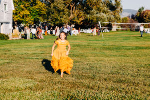 Little girl running on the lawn at McVey Homestead outdoor wedding reception