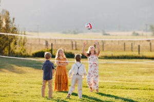 Western Montana kids playing volleyball on lawn at McVey Homestead wedding reception