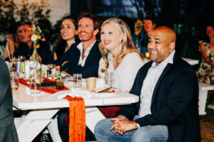 Guests sitting at picnic tables during evening wedding reception at McVey Homestead
