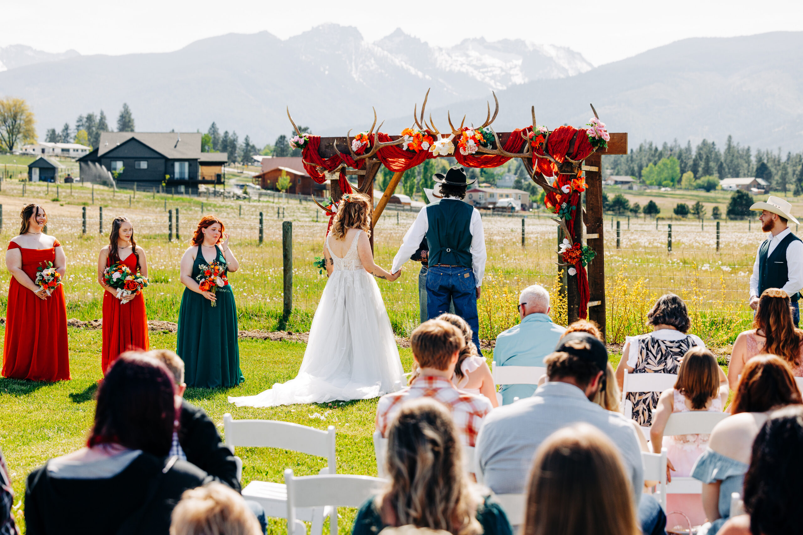 Outdoor ceremony on lawn at McVey Homestead with Bitterroot Mountains in background