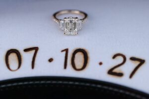 Close-up of engagement ring sitting atop cowgirl had imprinted with wedding date
