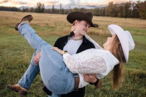 Man carrying his fiance in a field at sunset at Lazy Sousa Ranch in Huson, MT