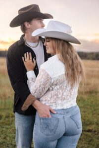 Engaged couple standing in field intimate moment at Lazy Sousa Ranch in Huson, MT